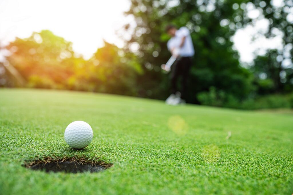 Close up golf ball on green grass field. sport golf club